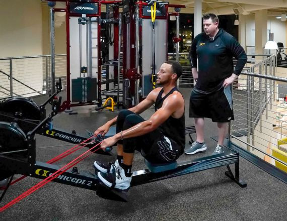 Golden State Warriors point guard Steph Curry works on core strength exercises with team trainer Brandon Payne.