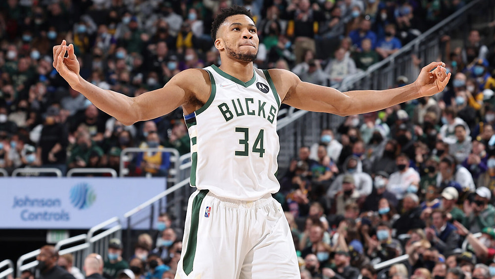 Milwaukee Bucks forward Giannis Antetokounmpo raises his arms in celebration after a made basket during an NBA basketball game.