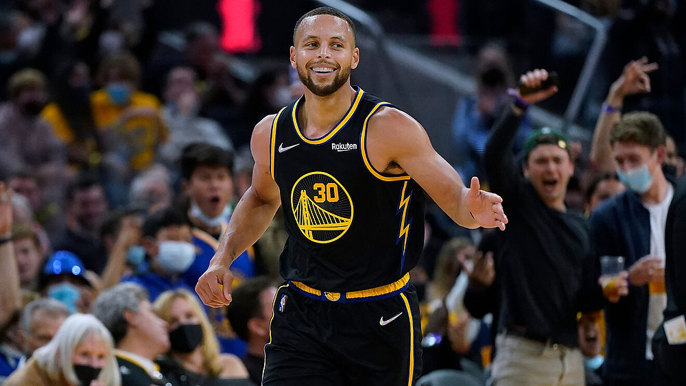 Golden State Warriors point guard Steph Curry extends his hand after a made basket during an NBA basketball game.