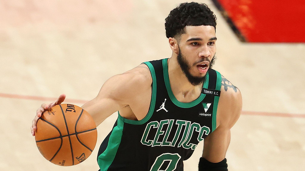 Boston Celtics forward Jayson Tatum dribbles the basketball on offense during an NBA basketball game.