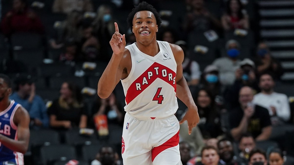 Toronto Raptors forward Scottie Barnes raises his finger in celebration during an NBA basketball game against the Philadelphia 76ers.