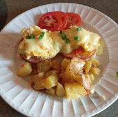 gourmet breakfast plate featuring Eggs Béarnaise, rosemary roasted potatoes, and fresh sliced tomatoes, contributing to a wonderful experience and accommodations at our B&B.