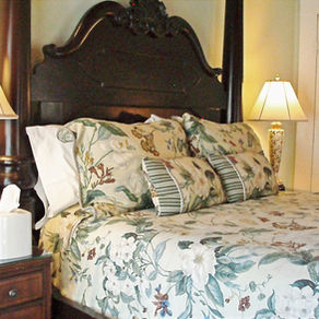 The elegant interior of the Princess Guest Room at the Judge Porter House, featuring a comfortable bed, high ceilings, and a quiet atmosphere for business travelers.