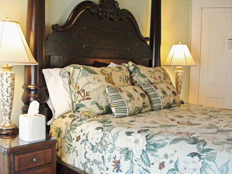 The elegant interior of the Princess Guest Room at the Judge Porter House, featuring a comfortable bed, high ceilings, and a quiet atmosphere for business travelers.