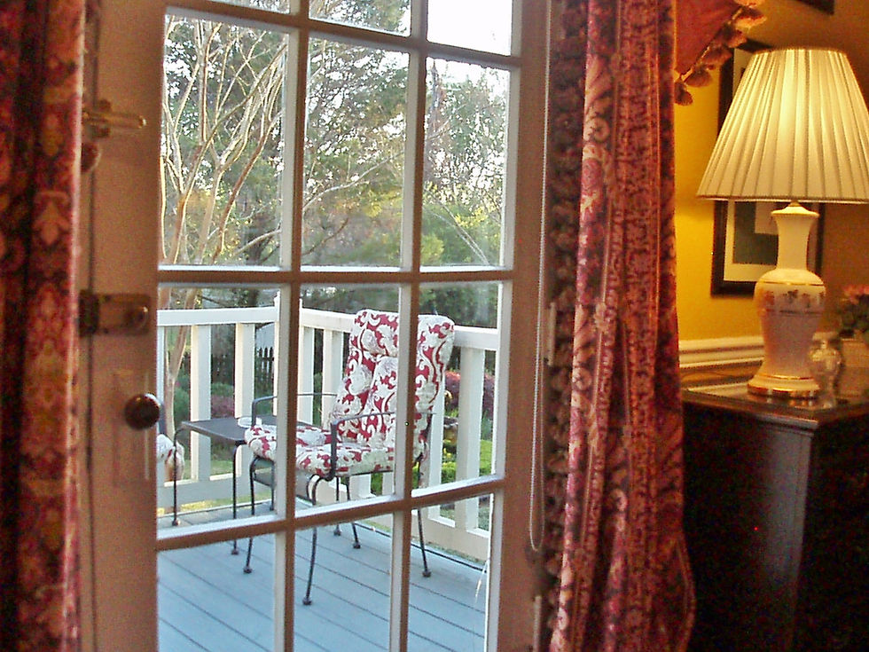 View from the Garden Room through open French doors leading to a private deck at a Louisiana bed and breakfast.