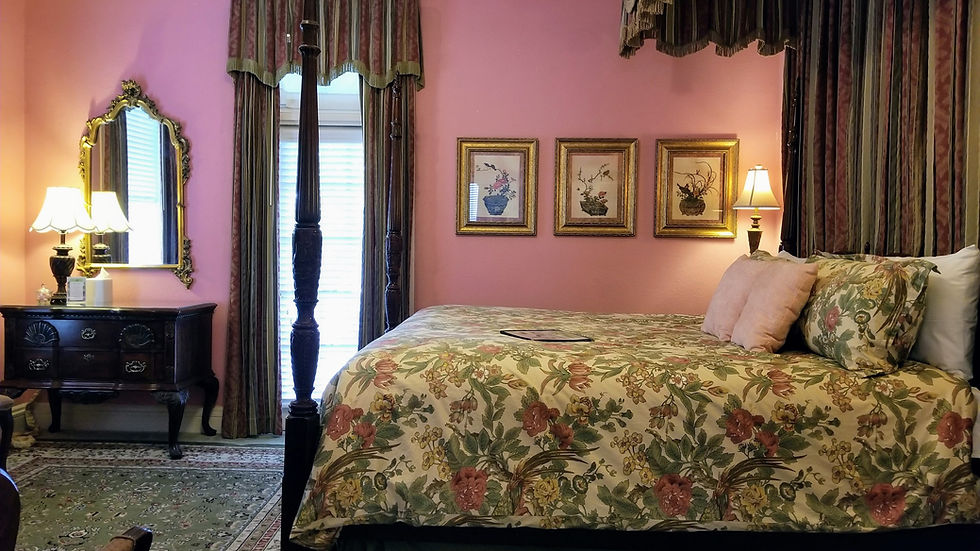 Shot of the Queen Anne Guest room featuring a king-sized four-poster bed and elegant vintage decor.