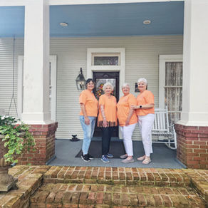 The four Moran Sisters smiling together on the beautiful front grounds of the historic Judge Porter House Bed and Breakfast during their joint birthday trip.