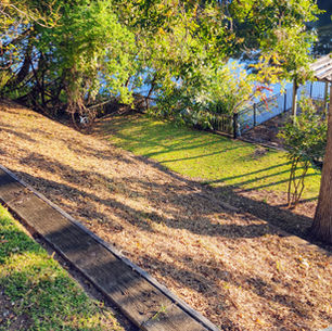 A peaceful back gallery at Violet Hill Bed and Breakfast featuring wicker chairs overlooking the serene Cane River Lake and a private boat dock