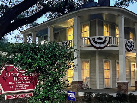 Judge Porter House Bed and Breakfast illuminated in the evening beneath large oak trees in Natchitoches, Louisiana.