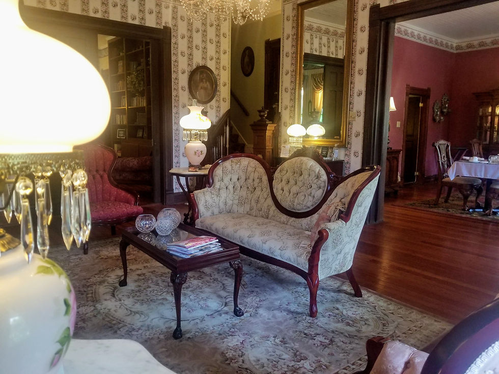 Vintage living room with ornate furniture, floral wallpaper, and crystal chandeliers. Soft lighting, elegant decor, and warm wooden floors.