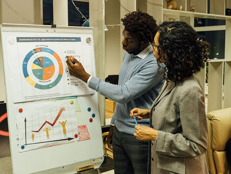 two people looking at business analytics on a white board