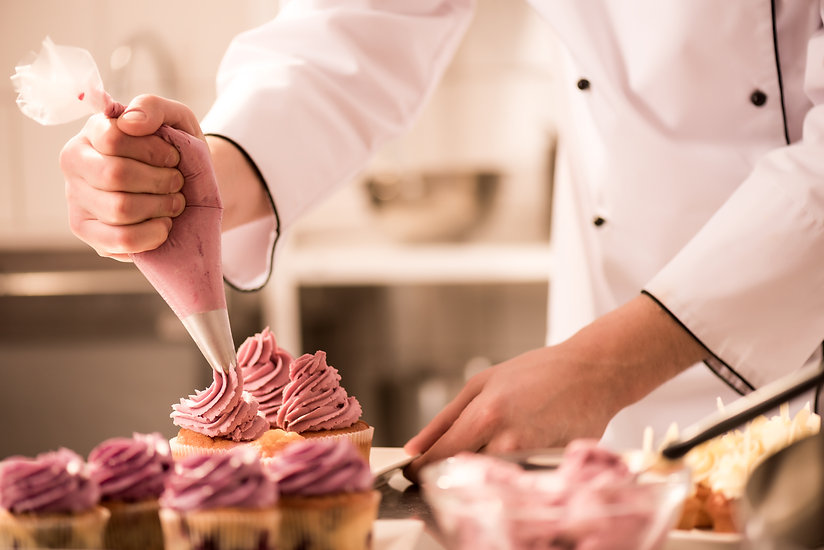 cropped-shot-of-confectioner-putting-cre