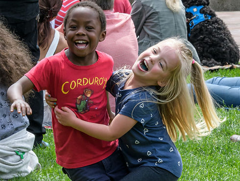 Two young kids play on the grass at a park concert in Bellingham, Washington, May 26, 2019