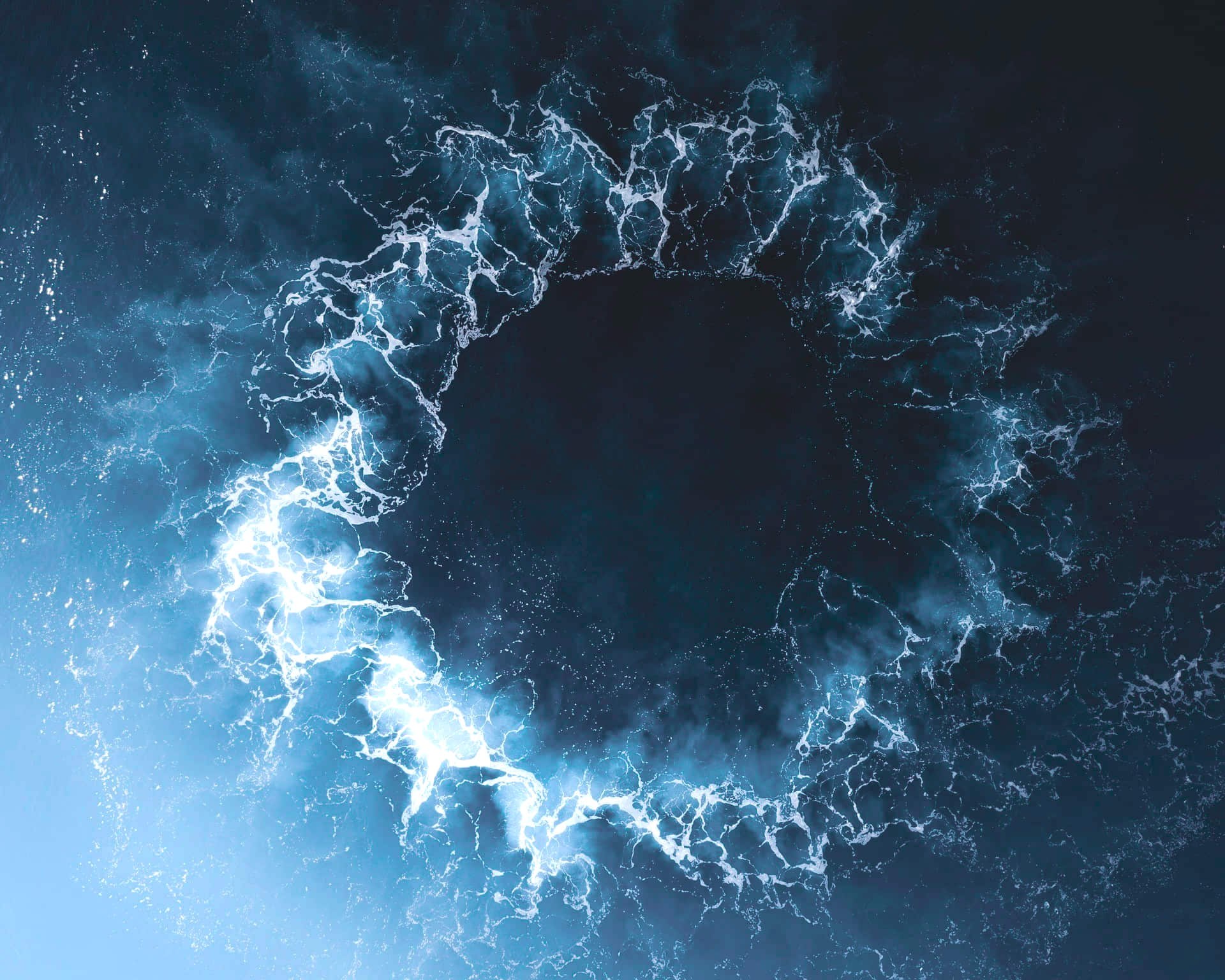 Vagues vues du ciel formant un cercle au sein d'un océan d'un bleu marine profond, comme les liens d'une communauté