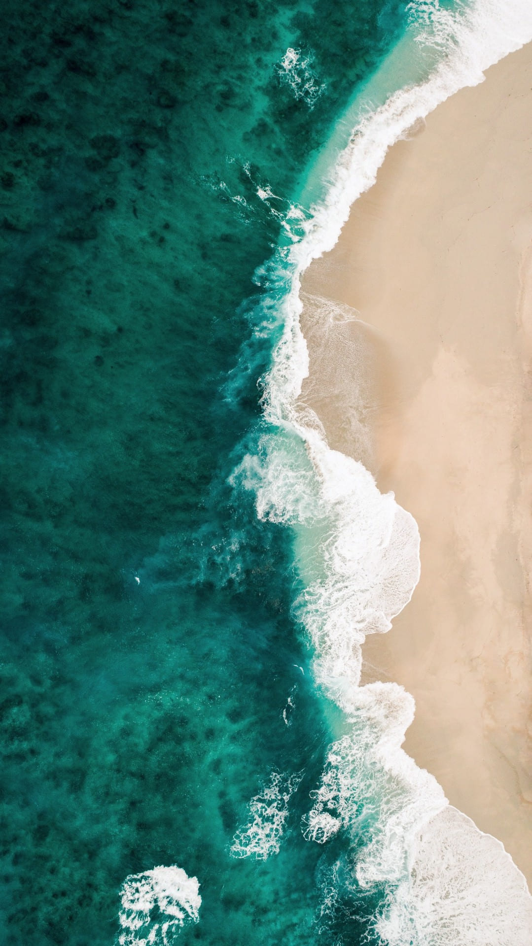Sable doré et mer d'un vert émeraude profond, plage vue du ciel, métaphore de nos mémoires prénatales
