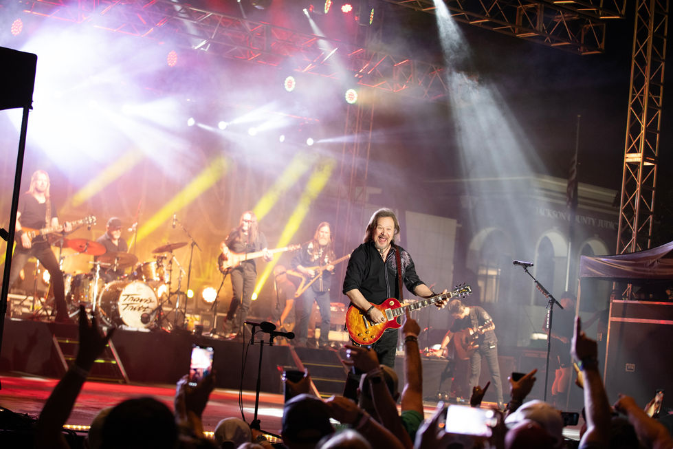 Band performing on stage with colorful lights.