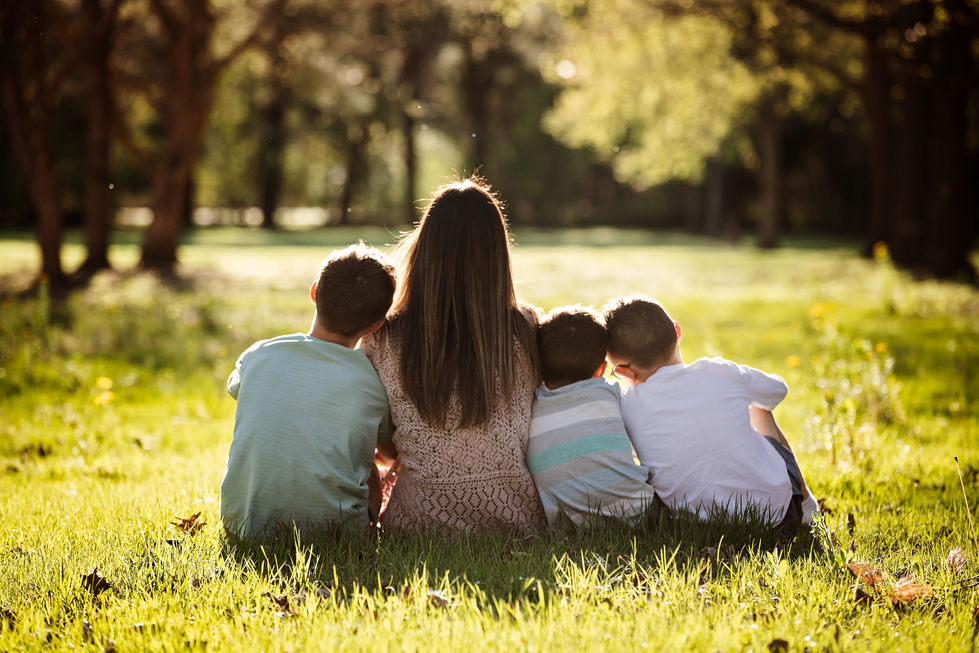 Family sitting together in a sunny park.