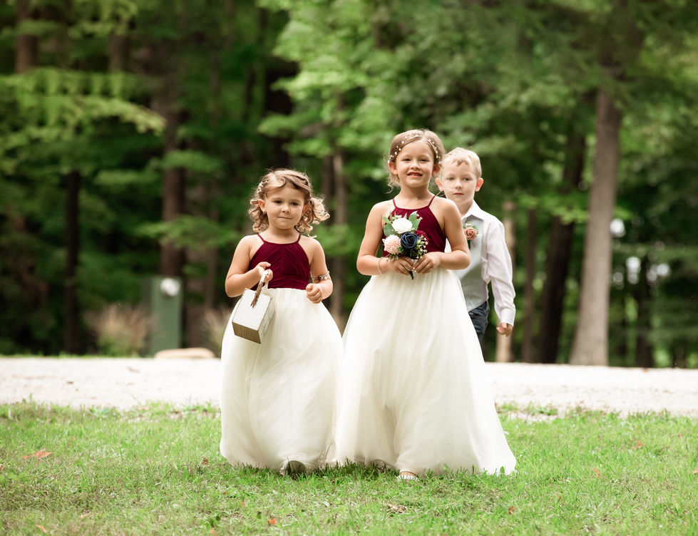 Three children in formal attire outdoors.