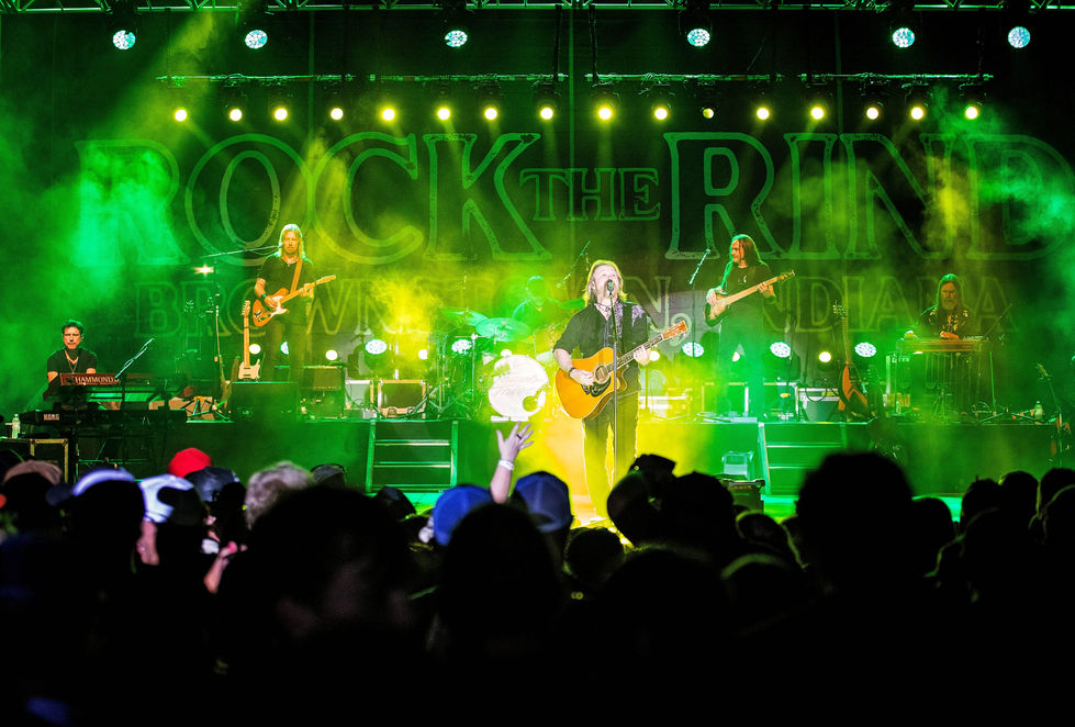Band performing on stage with vibrant green lights.