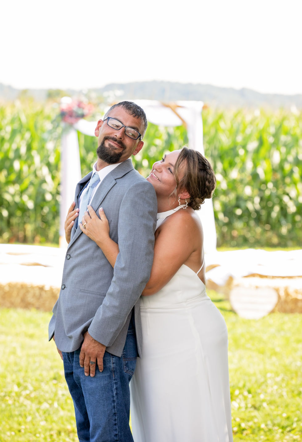 A couple posing happily outdoors at a wedding.