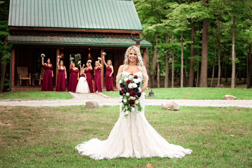 Bride in white dress with bridesmaids in background.