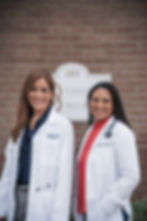 Dr. Garland and Dr. Cardona in white coats standing in front of clinic