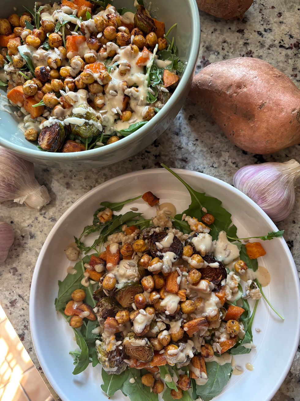 Roasted veggie salad with Brussels, sweet potato and chickpeas over a bed of arugula with tangy tahini vinaigrette and sunflower seeds