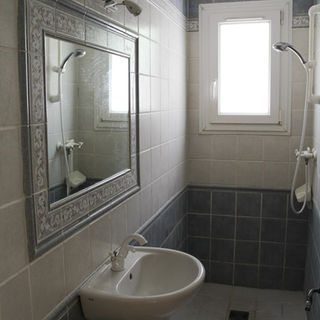 Separate shower room with walk-in tiled shower, basin, and a window that opens onto the garden of a villa rental in the Luberon region near Lourmarin.