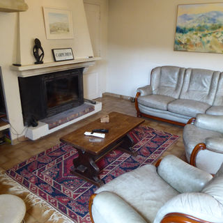 Spacious living room with  fireplace, leather seating, and artwork in a Provence holiday villa near Lourmarin.