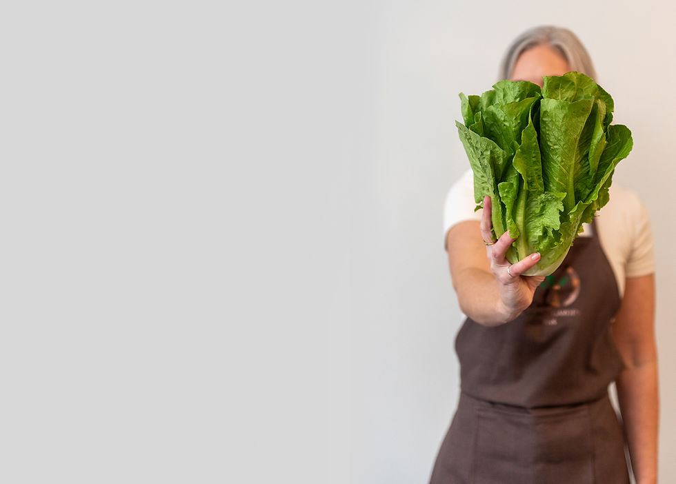 owner holding lettuce in front of her face