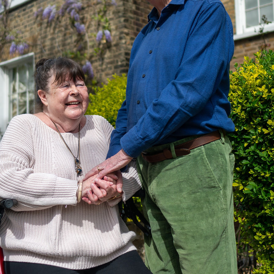An older couple with disabilities hold hands outdoors._edited.jpg