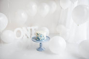 Blue art decor cake smash. White cake with blue splatter first birthday cake smash.