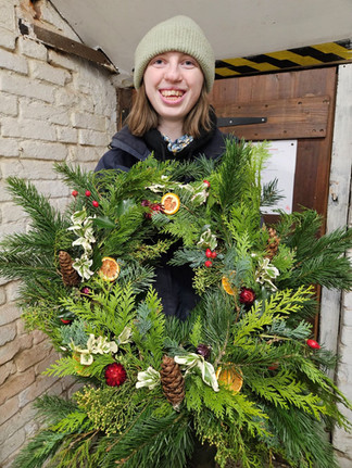 Gardener holding Christmas Wreath, Houghton Hall Walled Garden, Norfolk UK