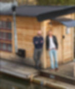 The owners standing beside the sauna boat. Alt: Grebo Bastubåt owners Alvin Berggren and Joaquim de Oliveira Pegado – builders behind the self-service sauna powered by Rentalbuddy.
