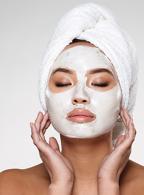 Close-up of skin therapist applying facial mask on a client