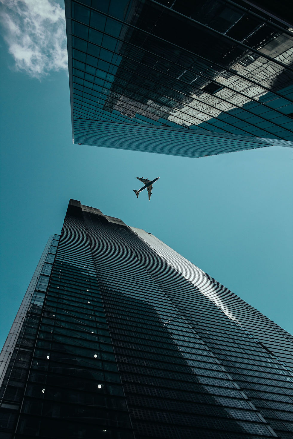 Vue en contre plongée d'un avion reliant deux buildings dans le ciel symbolisant la médiation