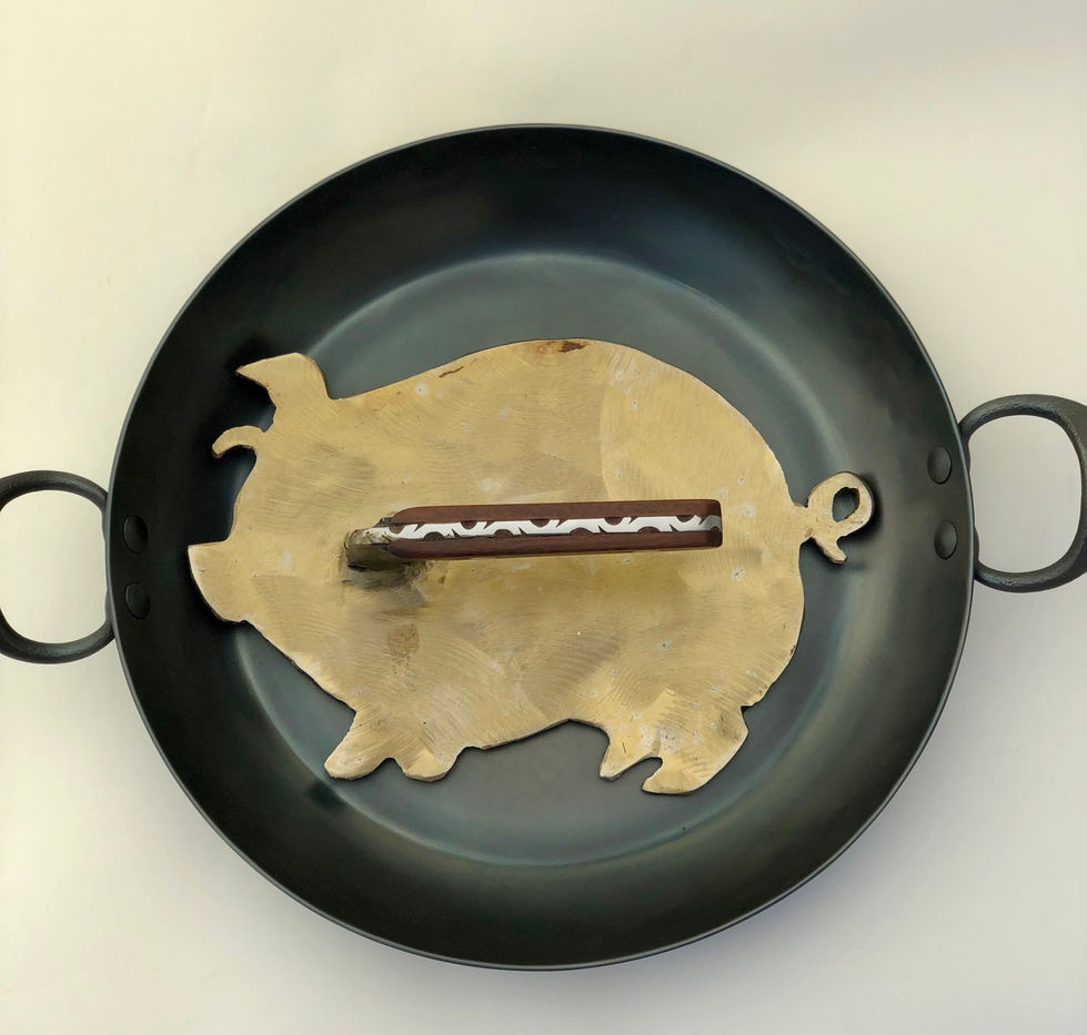 pig shaped bacon press, with a handle made from a dark hardwood and steel.  The top steel edge is hand filed with a nice pattern.