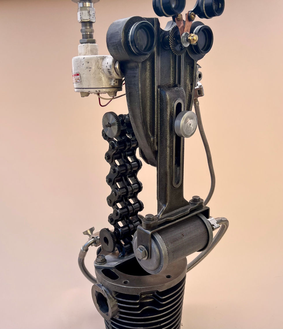Robot from heavy cast iron piece, binoculars, roller chain and miscellaneous parts on a base from an old motor