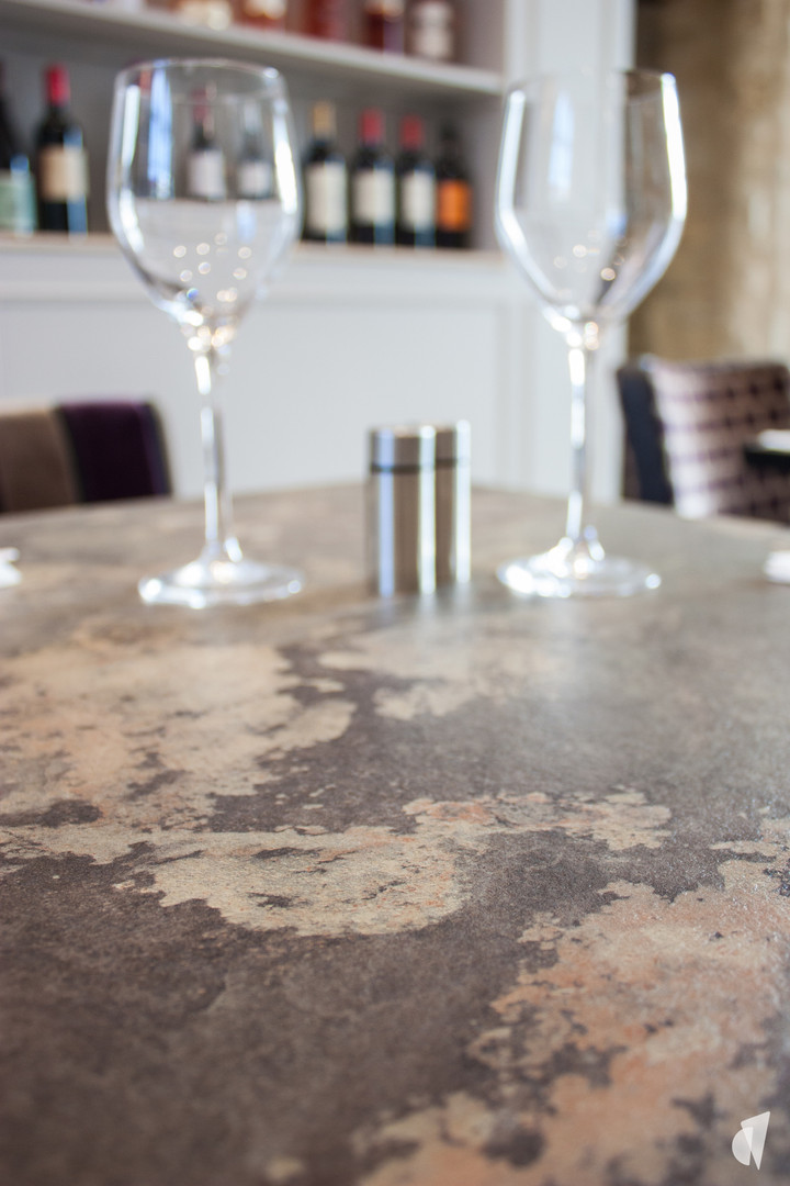 Agencement et décoration de restaurant à Annecy par l'architecte d'intérieur Coralie Vasseur : table plateau texture pierre
