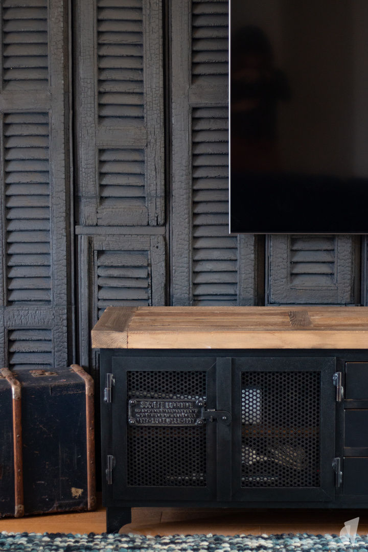 Décoration d'une pièce de vie au style industriel bleu à Aix les Bains, par Studio Coralie Vasseur : meuble indus et mur en bois brûlé