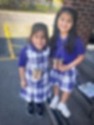 Two female students standing outside of school