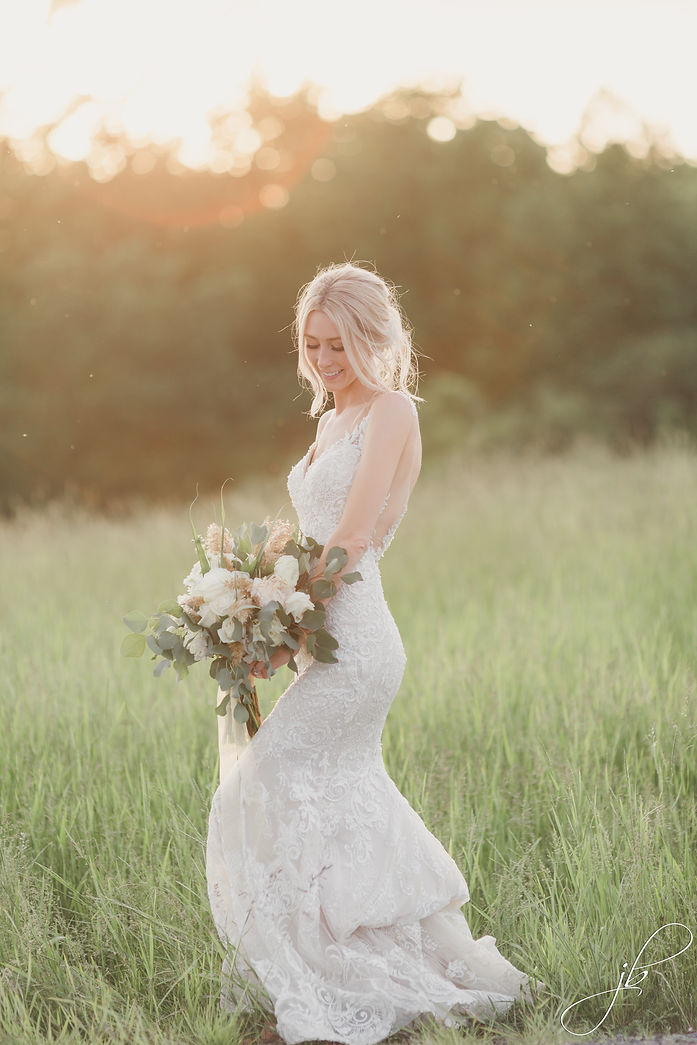Bride Smiling holding flowers at sunset
