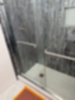 A modern walk-in shower featuring floor-to-ceiling dark slate tiling, a built-in niche, and professional glass door installation. For high-end bathroom remodeling and tile work, call Solano Property Maintenance at 626-344-0337