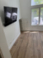 A large flat-screen television perfectly wall-mounted on a clean interior wall with all cables hidden, representing our professional fixture and electronics installation services. For a clean, cord-free TV setup, call Solano Property Maintenance at 626-344-0337