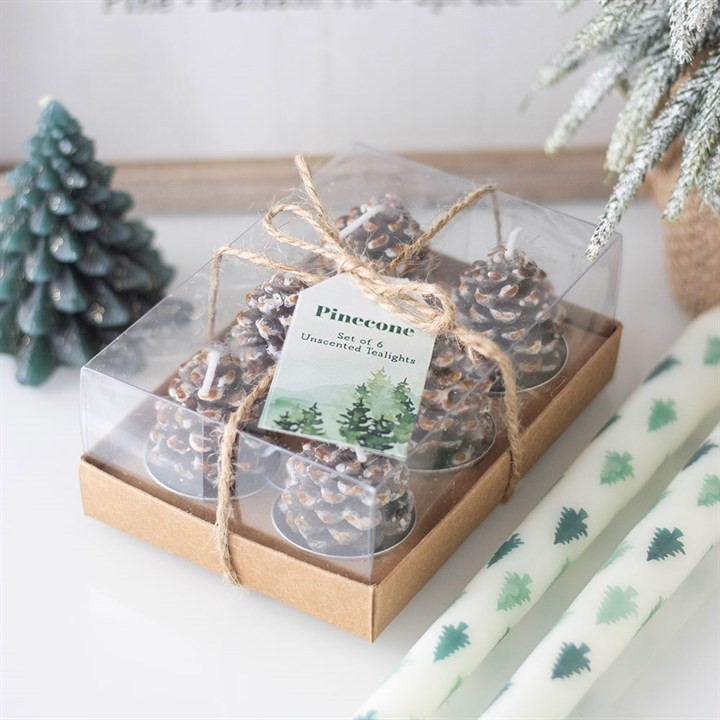 charming gift box containing 6 fir tree pine cone shaped cables tea lights. christmas themed with snow tipped pine cones