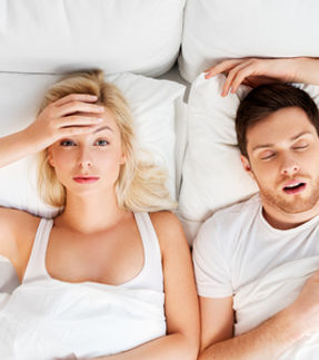 116793209-femme-malheureuse-au-lit-avec-un-homme-endormi-qui-ronfle.jpg