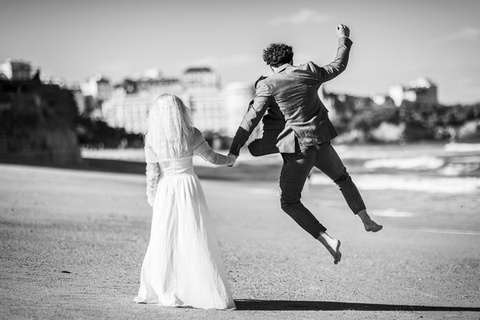 Photo de couple de mariés sur une plage après le mariage