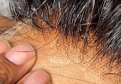 Bleached lace closure held against hand to showcase natural scalp-like results.