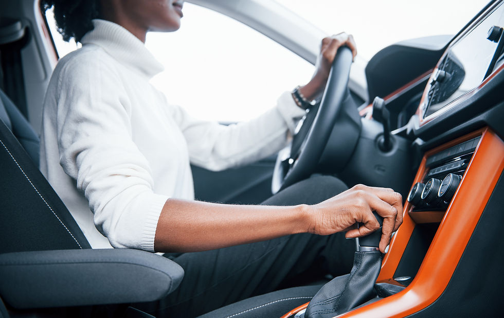 Young african american woman sits inside of new modern car.