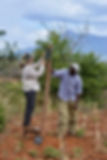 two people by a wooden pole in Kenya